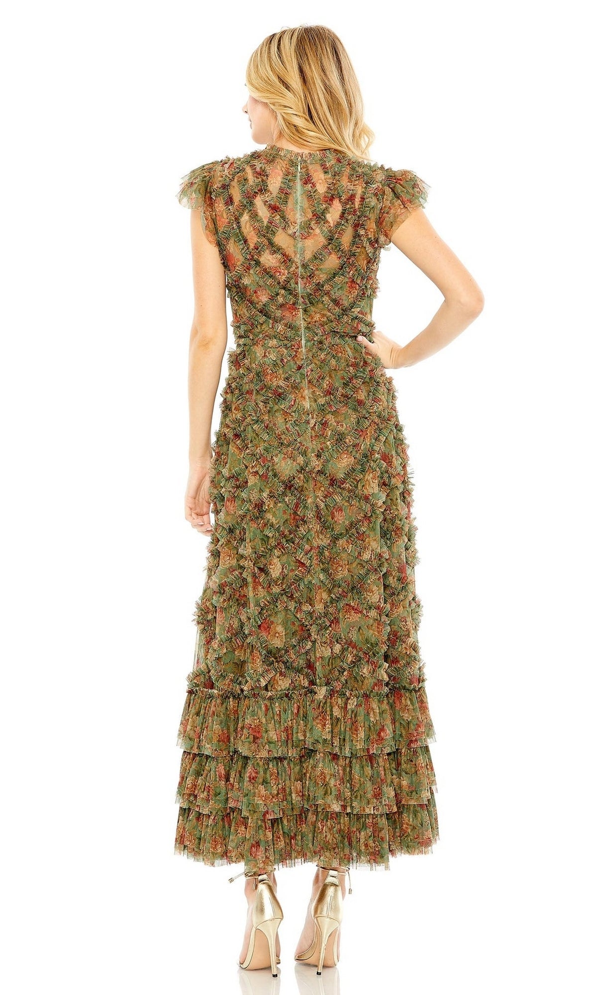 A woman stands facing away, wearing the Mac Duggal Knee Length Wedding Guest Dress 8009 in green and orange with cap sleeves and tiered ruffles, paired with metallic heels—ideal for a chic wedding guest look.